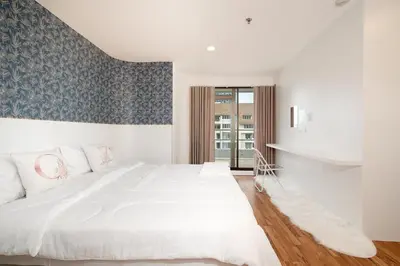 a white bedroom with a large bed and a window at Elegant King BR Apt Bathtub, BTS Central BKK BTB8 in Bangkok