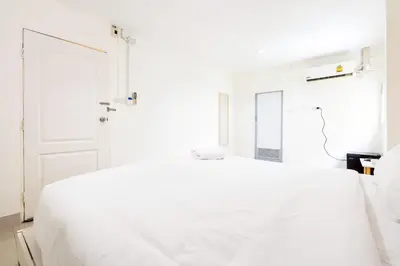 a white bedroom with a white bed and a door at xx Oh My Napz Sukhumvit 3 - สุขุมวิท ซอย 3 in Makkasan