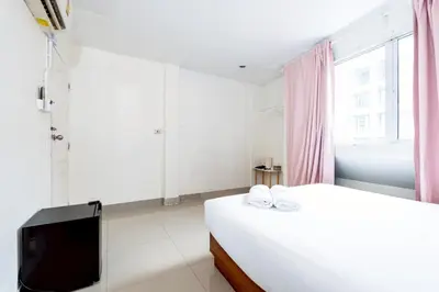 a white bedroom with a bed and a tv at xx Oh My Napz Sukhumvit 3 - สุขุมวิท ซอย 3 in Makkasan