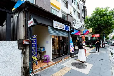 a woman standing on a sidewalk in front of a store at xx Oh My Napz Sukhumvit 3 - สุขุมวิท ซอย 3 in Makkasan