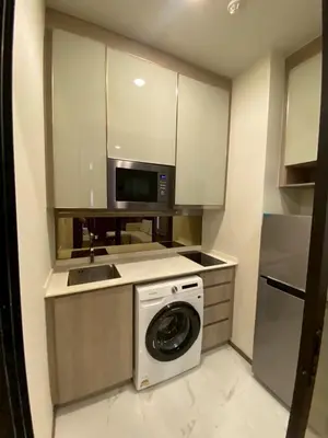 a kitchen with a washing machine and a microwave at Park payathai 28 in Bangkok