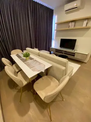 a living room with a table and chairs and a television at origin phayathai 28 in Bangkok