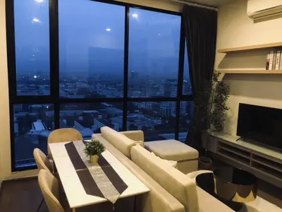 a living room with a table and chairs and a large window at origin phayathai 28 in Bangkok