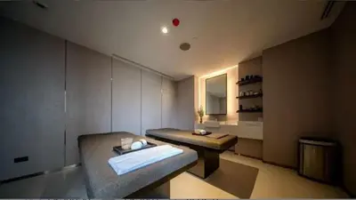 a room with a bench and a table and a mirror at origin phayathai 28 in Bangkok