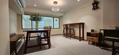a living room with a dining room table and chairs at Loly Residence in Bangkok