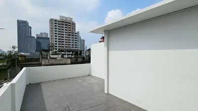 a white wall on a balcony with a city skyline at Loly Residence in Bangkok