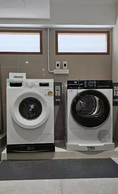 a washing machine and a washer in a room at Loly Residence in Bangkok