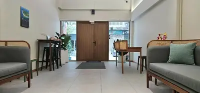a living room with two couches and a door at Loly Residence in Bangkok