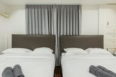 two beds sitting next to each other in a bedroom at SavasdeeVilla Midtown bangkok in Makkasan