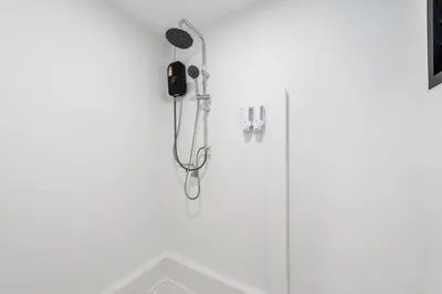 a shower with a blow dryer in a bathroom at SwasddeeHouse midtown bangkok in Makkasan