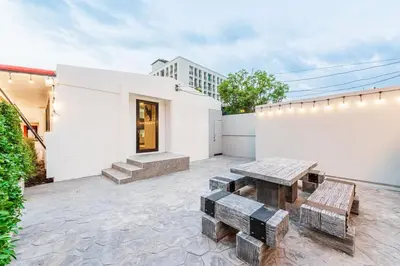 a patio with a wooden table and benches at SwasddeeHouse midtown bangkok in Makkasan