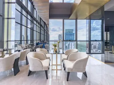 a waiting room with chairs and a table and large windows at New City Condo in Central Bangkok Siam Paragon Central World in Pratunam