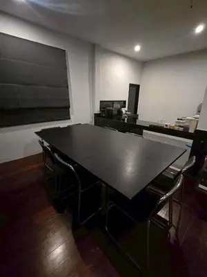 a large black table in a room with chairs at Little Tree Hut Bangkachao in Bang Chak