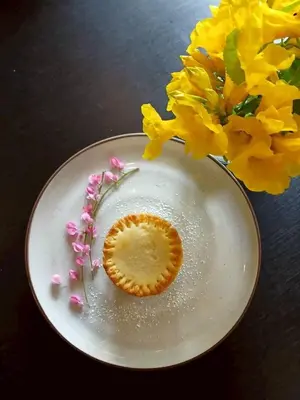 a white plate with flowers on a table at Little Tree Hut Bangkachao in Bang Chak