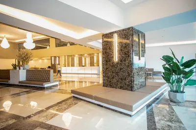 a lobby with a fountain in the middle of a building at Enrich Grand Hotel in Bangkok