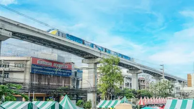 a train on a bridge over a city with tents at Enrich Grand Hotel in Bangkok