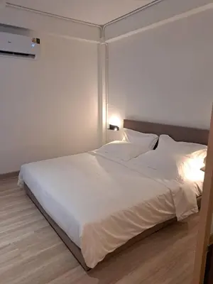 a bedroom with a large white bed with white sheets at Brown H in Pom Prap