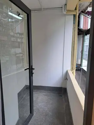 an empty room with a glass door in a building at Brown H in Pom Prap