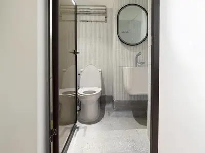 a bathroom with a toilet and a sink and a mirror at Brown H in Pom Prap