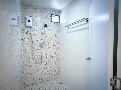 a bathroom with a shower with a glass door at Nortas Tha Phra in Bangkok