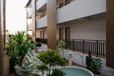 an apartment building with a courtyard with plants at Morning Place in Ban Krathum Lom
