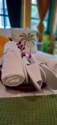 a pile of towels and a flower on a bed at Dar Wafa Riad, Restaurant and Hamam in Bangkok