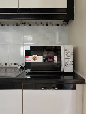 a microwave sitting on a counter in a kitchen at Bann-Kun Impact Muang Thong 2BR Condo Wi-Fi MRT Pink Near Airport DM