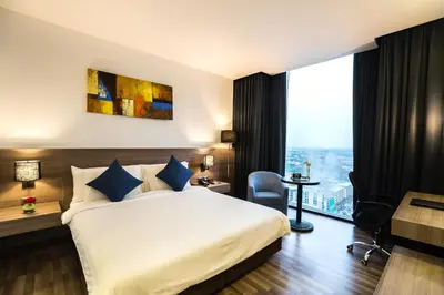 a hotel room with a bed and a desk and a window at Best Western Plus Wanda Grand Hotel in Nonthaburi