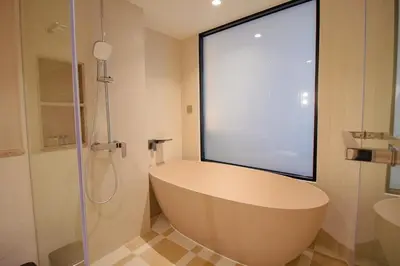 a bathroom with a large window and a bath tub at Marwin Terra Hotel in Bangkok