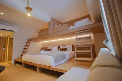 a bedroom with a bed and a bunk bed at Marwin Terra Hotel in Bangkok