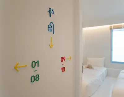 a room with clocks on the wall next to a bed at Bedd Hostel in Bangkok