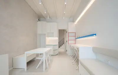 a laboratory with white tables and stools in a room at Bedd Hostel in Bangkok