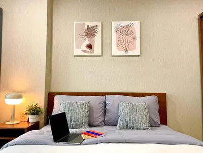 a bedroom with a bed with a laptop on it at 1-Min Walk to BTS Thonglor Simple Spotless Great Value Stay in Khlong Toei