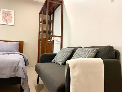 a living room with a couch and a mirror at 1-Min Walk to BTS Thonglor Simple Spotless Great Value Stay in Khlong Toei