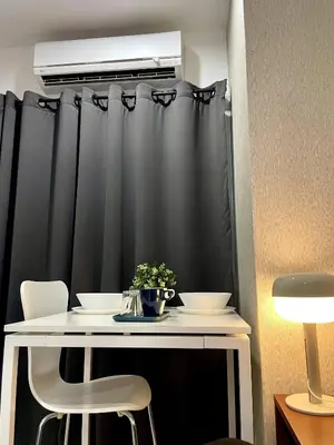 a dining room table with two chairs and a heater at Thonglor BTS 1-Min Walk Easy Check-In Laundromat in Khlong Toei