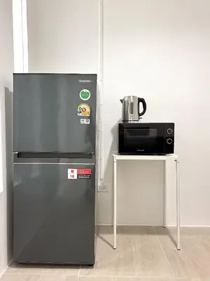 a refrigerator and a microwave next to a table at 1minBTS-Wifi500Mbs-Workplace>NETFLIX/Central in Khlong Toei