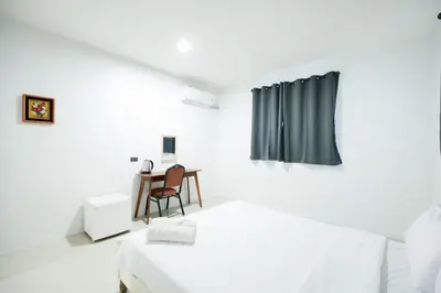 a white room with a bed and a table at XX Snap Sukhumvit 1 -BTS Nana Bangkok in Makkasan