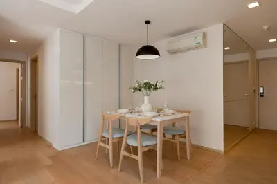 a white dining room with a table and chairs at 2BR2BA BTS Thonglor Rooftop Pool Gym BBQ Low in Bangkok