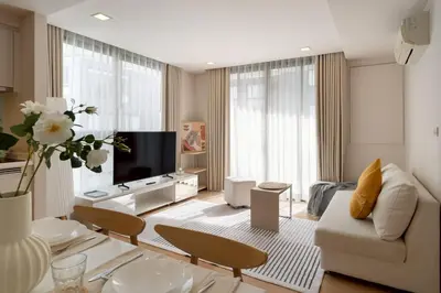 a living room with a couch and a tv at 2BR2BA BTS Thonglor Rooftop Pool Gym BBQ Low in Bangkok