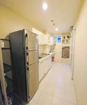 a kitchen with a stainless steel refrigerator and white cabinets at MahaNakhon Silom Sathon in the heart of Bangkok in Bangkok