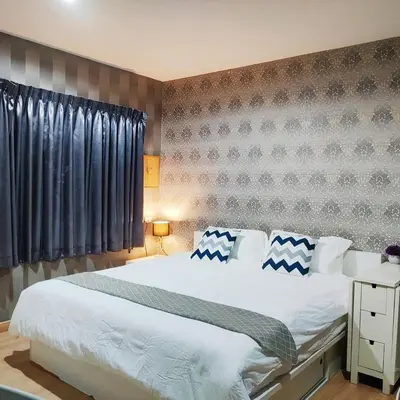 a bedroom with a large white bed with blue and white pillows at MahaNakhon Silom Sathon in the heart of Bangkok in Bangkok