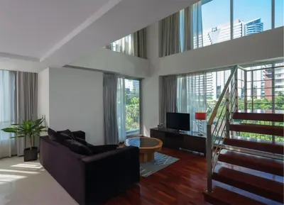 a living room with a couch and a tv at Silom Lofts in Bangkok