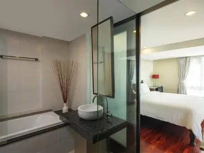 a bathroom with a sink and a bed and a tub at Silom Lofts in Bangkok