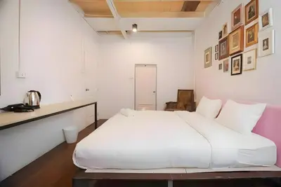 a white bedroom with a large white bed in it at Mitr Inn Yaowarat Road in Samphanthawong