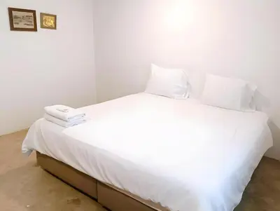 a white bed with white sheets and pillows on it at Mitr Inn Yaowarat Road in Samphanthawong