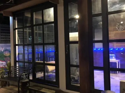 a room with windows looking out onto a patio at Bluefin Guesthouse in Bangkok