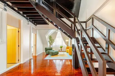 a living room with a staircase in a loft at \u66fc\u8c37\u5e02\u4e2d\u5fc3\u7d20\u5764\u9038\u73b0\u4ee3\u5317\u6b27\u98ce5\u5367\u72ec\u680b\u522b\u5885 in Bangkok