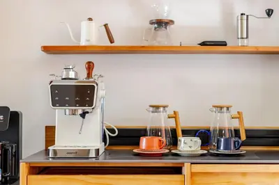 a kitchen counter with a coffee maker and two cups at \u66fc\u8c37\u5e02\u4e2d\u5fc3\u7d20\u5764\u9038\u73b0\u4ee3\u5317\u6b27\u98ce5\u5367\u72ec\u680b\u522b\u5885 in Bangkok
