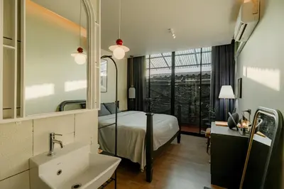 a bedroom with a bed and a sink and a mirror at Nap Old Town in Bangkok
