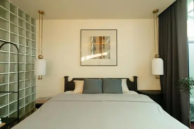 a bedroom with a large white bed with two lamps at Nap Old Town in Bangkok